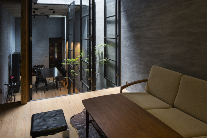 「奈良きたまちの店舗併用住宅(カフェ・テナント)」中2階のサロンスペースから1階カフェスペースを見る。高さを変えることで、空間に広がりを感じることができる