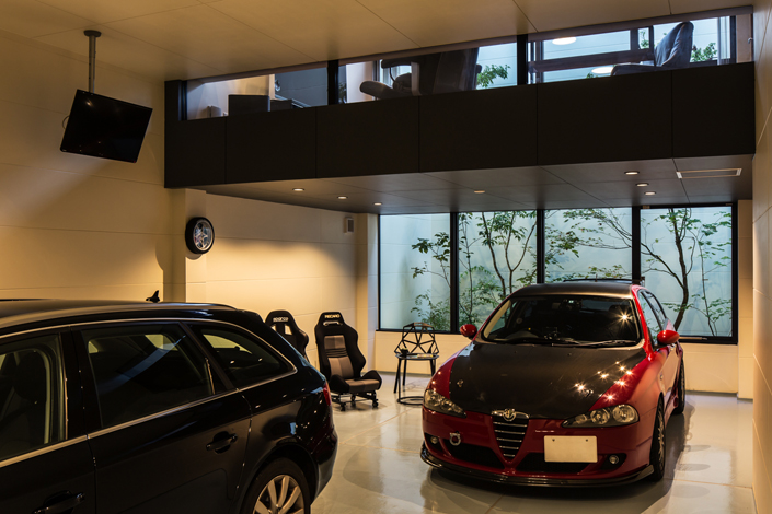 「山科のガレージハウス・京都」クルマ2台以外にバイクも格納できるガレージ。リビングからもガレージ内の愛車が眺められるように窓を設置