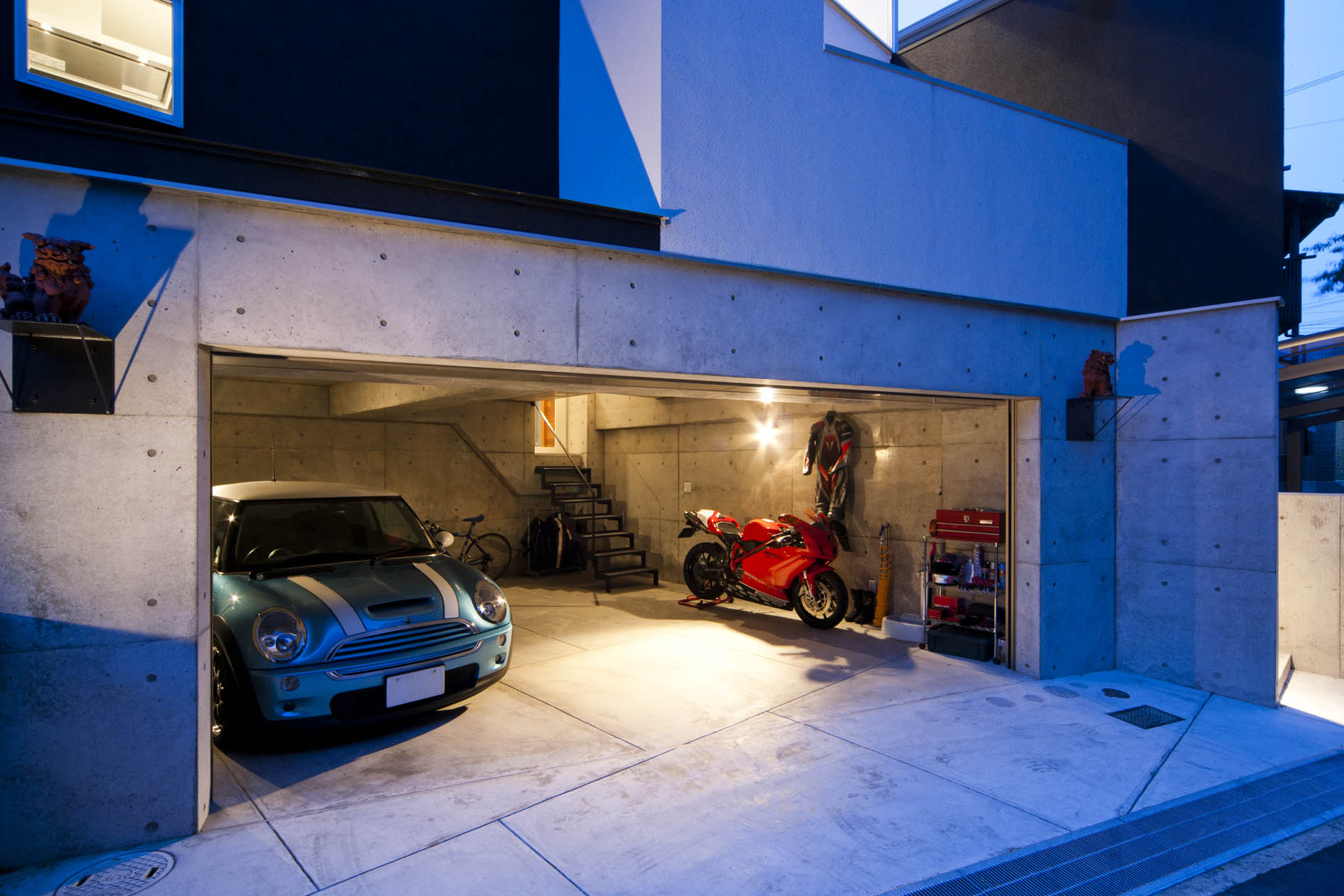 「青葉台のガレージハウス・西宮」ガレージを見る。クルマ2台を並列駐車した横にさらにバイクを置く余裕がある。設計／田中一郎