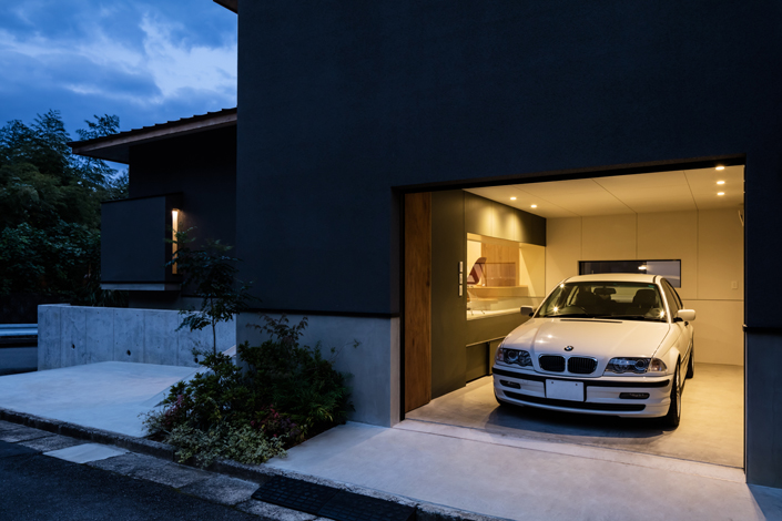 「京都・西山のガレージハウス」<blockquote>ガレージ夕景を見る。内壁にはグリーンを。ガラス窓は玄関と中庭に面しており、家と車がつながる。 設計/藤原誠司 施工/㈱山本安工務店 撮影/笹倉洋平
