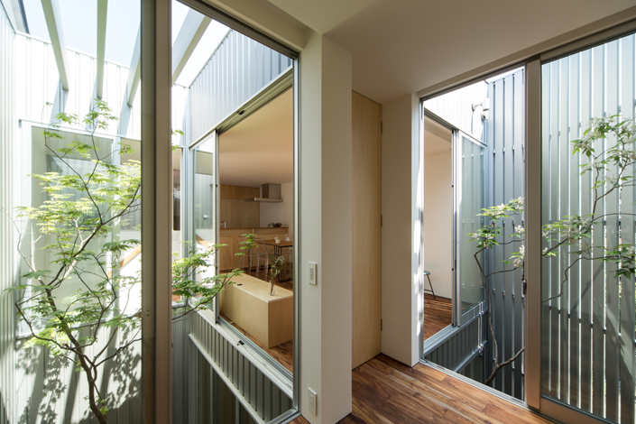 「鳳の狭小ガレージハウス・大阪(建築面積 約13.4坪)」<blockquote>2階の中庭とダイニングキッチンを見る。限られた敷地かつ隣家が迫る土地でプライバシーを確保しながら光と風を採り込むため、中庭を2カ所採用している。
設計/堤 康策 施工/㈱山本安工務店