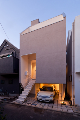 「府中の狭小住宅 ・東京」外観を見る。玄関を2階に配置することで、1階にクルマ、バイク、自転車を駐車できるスペースを確保している。