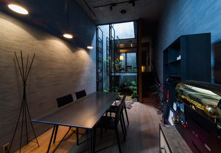 「奈良きたまちの店舗併用住宅(カフェ・テナント)」1階のフリースペース(今後カフェとして利用予定)から中庭、中2階のサロンを見る。開口に設けられた高さ3.8メートルのスチールサッシなど、極力既製品や新建材を避け、本物の素材を選ぶことで上質な空間を演出。<br /> 設計/藤原誠司 撮影/平野和司